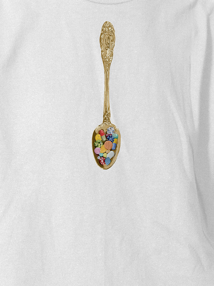 A close-up of a white printed t-shirt by useless treasures. Print of an illustrated golden spoon filled with pills and gems. 