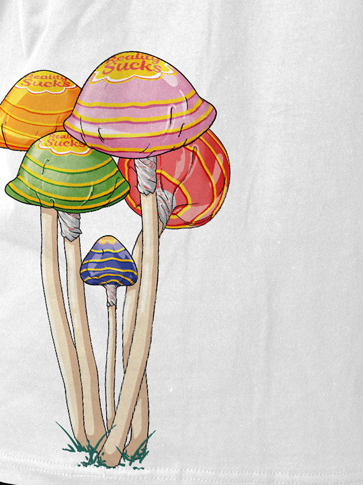 A close-up of a white printed t-shirt by useless treasures. Print of an illustrated​bunch of magic psychedelic mushrooms wrapped in a lollypop wrap saying reality sucks. 